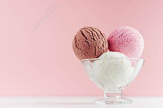 Ice cream scoops different flavor - strawberry, chocolate, creamy  in transparent glass ice-cream bowl in modern pink color.
