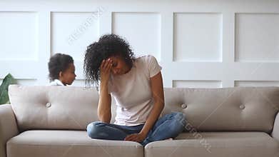 Upset african single mother feeling stressed about active noisy children