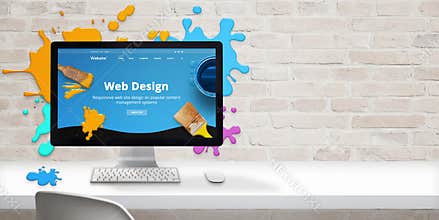 Web design studio concept with modern web site teme and web design text on computer display surrounded by color drops