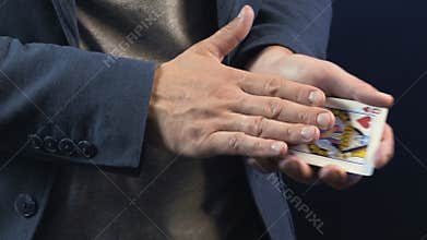 Shooting of magician showing trick with playing cards