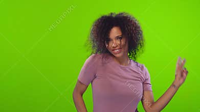 Active energized Afro woman dances and has fun feels amused and upbeat
