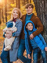 Happy Parents with a child on a walk in the fall. Family
