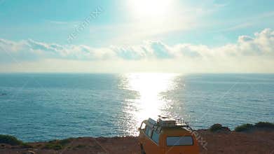 California, United States, JULY 20TH, 2019: Aerial view. Yellow VW bus van on a parking lot on a rock near the sea.