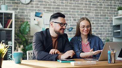 Cinemagraph loop of happy coworkers using laptop while steam going up from drink