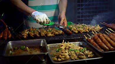 Slow Motion Vendor cooking Taiwanese chicken on stick. Night market street.
