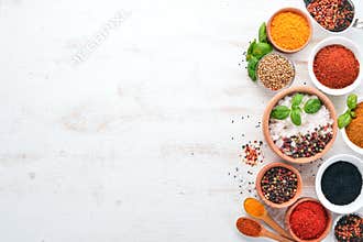 A set of Spices and herbs on a white wooden table. Basil, pepper, saffron, spices. Indian traditional cuisine.