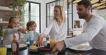Family having food at dining table in kitchen at comfortable home 4k