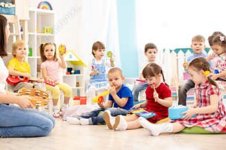 Group of kindergarten children play with musical toys. Early musical education in daycare