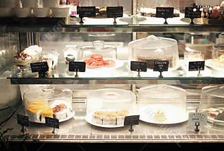 Desserts on sell with names and prices in bakery shop