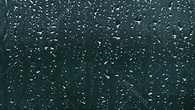 Close-up of rain droplets falling on window. Rainy day.