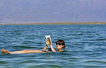Girl floating at the Dead Sea
