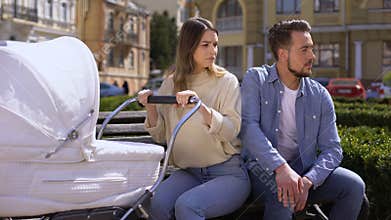 Young husband looking at women on street, jealous wife crying swinging pram