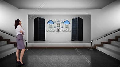 Business woman looking at server towers for cloud storage