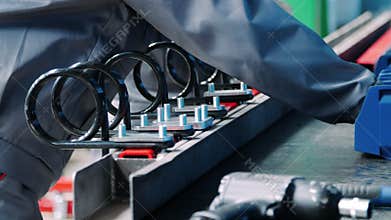 Workers assemble industrial unit from metallic parts at factory