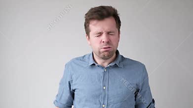 Young crazy man hitting himself in face punishing himself with hands.