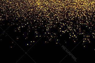 Abstract gold defocused glitter holiday background on black. Falling shiny sparkles. New year Christmas glowing backdrop