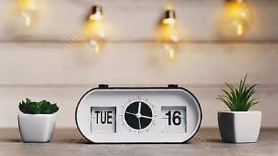 A white flip clock on table turns through month, flipping days and date, countdown from 1st to 31th
