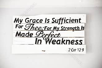 Closeup shot of a white wooden sign with a bible quote and a white background