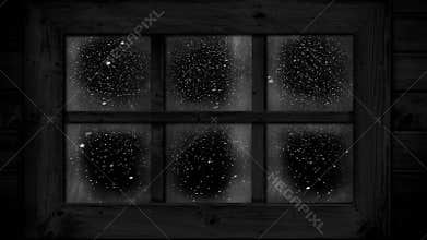 Snow falling outside window at night