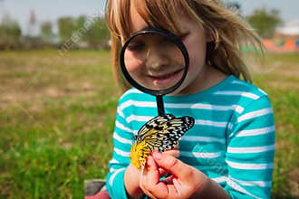Cute girl looking at butterfy, kids learning nature