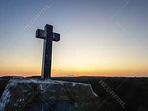 Huge wooden Orthodox eight-pointed cross against the sky after the dawn on Mount Athos
