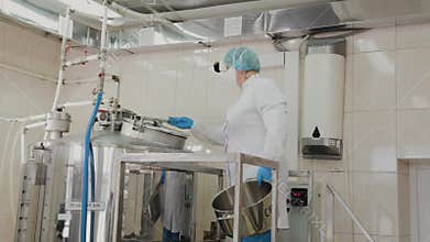 Female scientist puts ingredients into the reactor for the preparation of medicines.