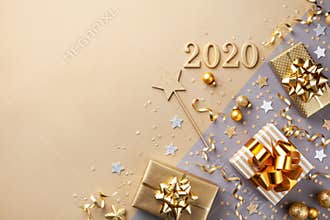 Golden gift or present boxes with golden bows, 2020 number and confetti top view. Christmas and New Year background. Flat lay