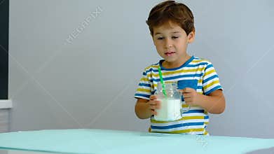 Slow motion asian Cute little kid drinking milk on kitchen. cheerful boy likes to drink milkshake