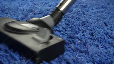 Woman Using Vacuum Cleaner Cleaning Blue Carpet