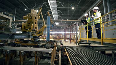 Men look at a working machine at a brick factory.