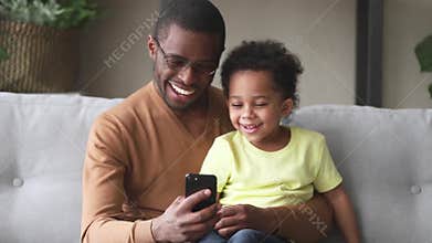African father spend time with son having fun using smartphone