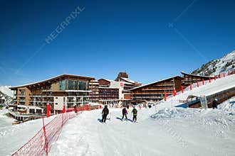 Skier on piste in mountain ski resort in sunny day