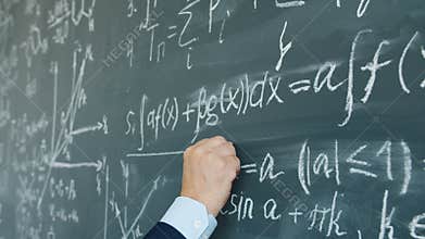 Slow motion of male hand underlining maths equation on chalkboard in class