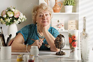 Woman of retirement age paints and decorates various items