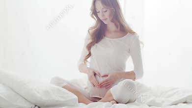 Happy pregnant woman touching her beautiful belly. Pregnancy, motherhood, and expectation concept