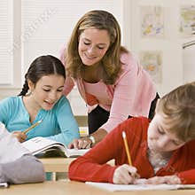 Teacher helping student in classroom
