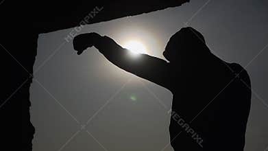 Silhouette. Boxer at sunset. Fulfills striking techniques. The shadow Boxing. Slow motion. Boxing and martial arts