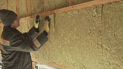 Man laying insulation in a wall
