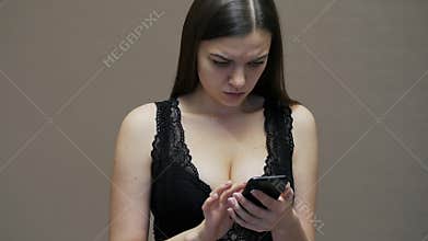 Wife or girlfriend use mobile phone of her husband, woman with big breasts dressed in underwear