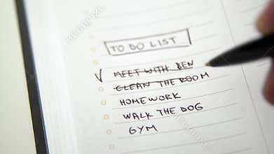 Human hand marking done task on to do list, checklist tick placed on chore notebook