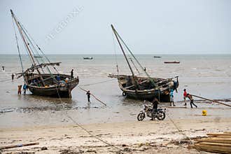 BAGAMOYO, TANZANIA - JANUARY 2020: local people fishermans on the big boat dhow in low tide. Historical Bagamoyo city