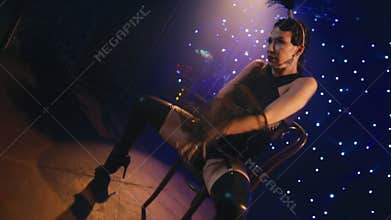 Sexy burlesque dancer women walking by stage and dancing around chair on stage