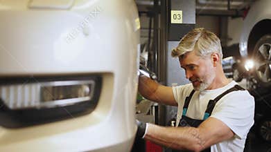 Man changing car wheel in tire fitting. Wheel bearings change the mechanic of car service concept in automobile center