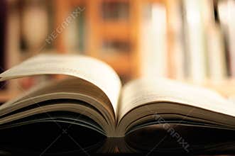 Open Book on Table with Bookshelf Background, Knowledge, Literature