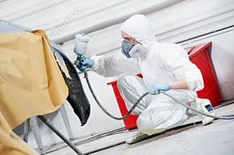Auto mechanic painting car bumper