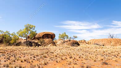 Granite boulders in a dry landscape against a blue sky