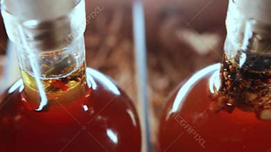Herbal alcoholic tinctures in a wooden box, close-up. Elite collection alcohol brandy and cognac. Movement from the