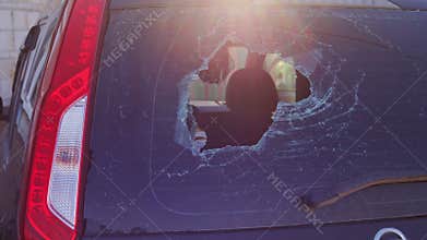 Broken glass in back door of car. Smashed rear window of auto