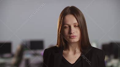 View of a young attractive businesswoman in a black business suit. Close-up shot of a young brunette in front of a