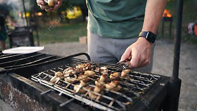 Close-up of grilled mushrooms champions in bbq grill net with hot coal underneath. Grilling cooking food outdoors in